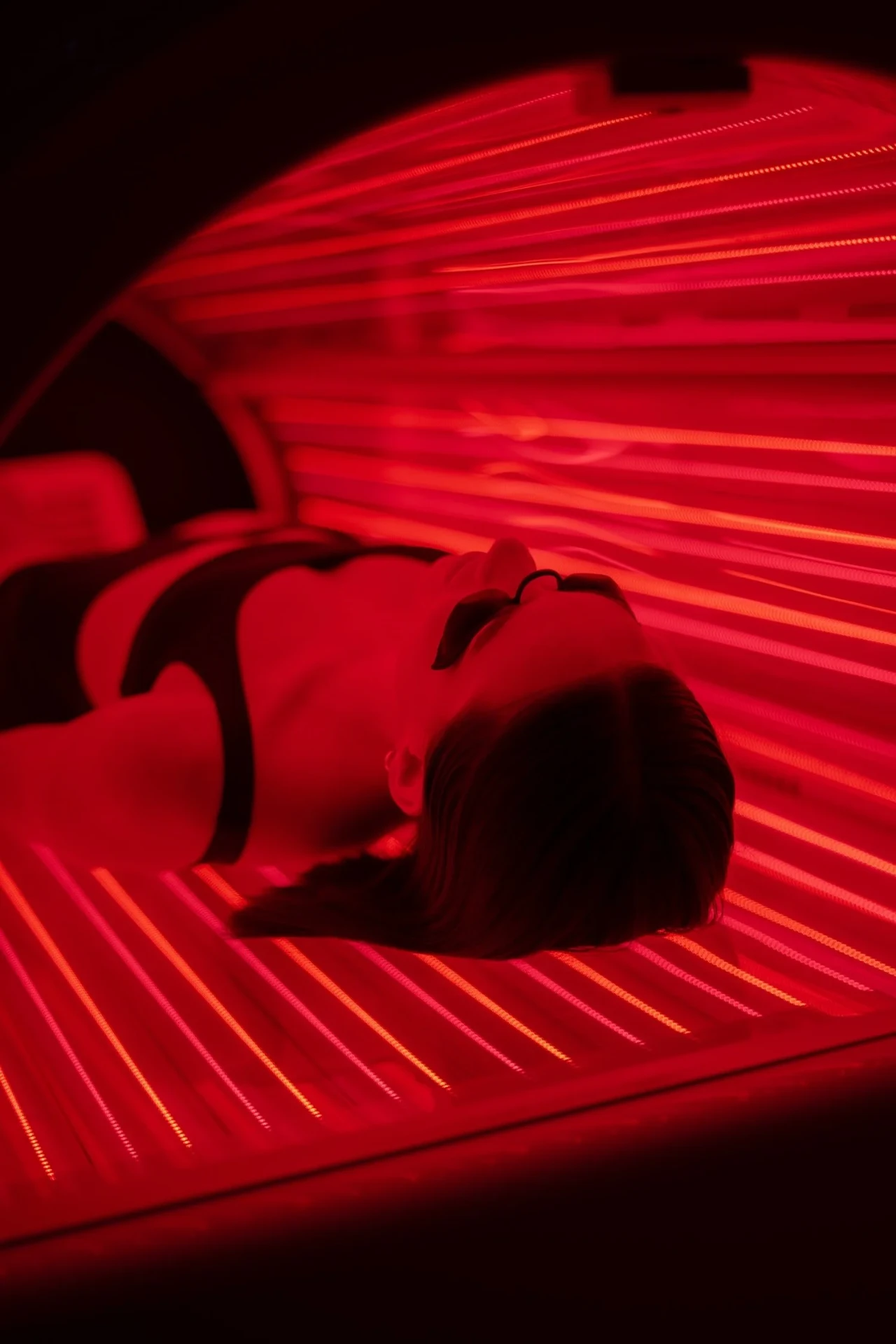 Red light therapy for athletes, pain relief, skin health, and longevity Red light therapy Pro-Bed session with dramatic red LED glow at REDSOL Wellness Club League City TX