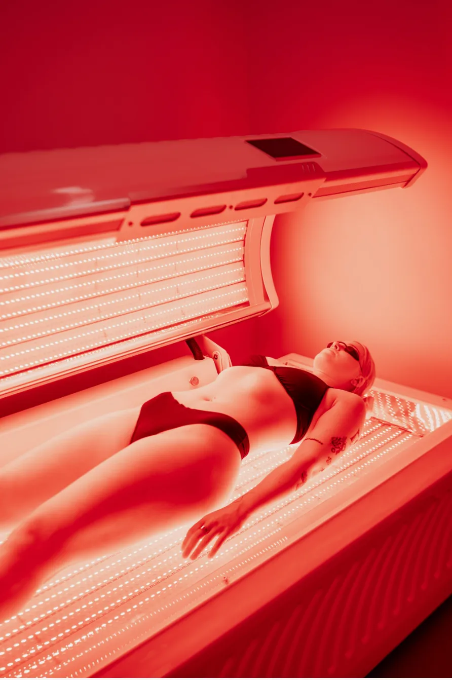 Red light therapy — anti-aging, skin rejuvenation, and cellular energy Woman receiving red light therapy session with therapeutic LED wavelengths at REDSOL Wellness Club League City TX